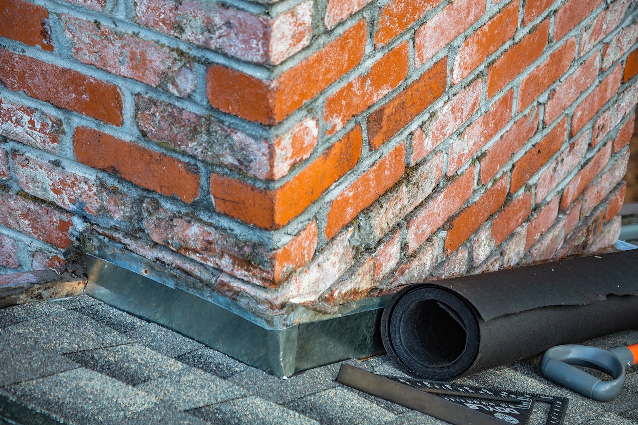 Detailed view of a brick chimney featuring construction tools and materials for repair.